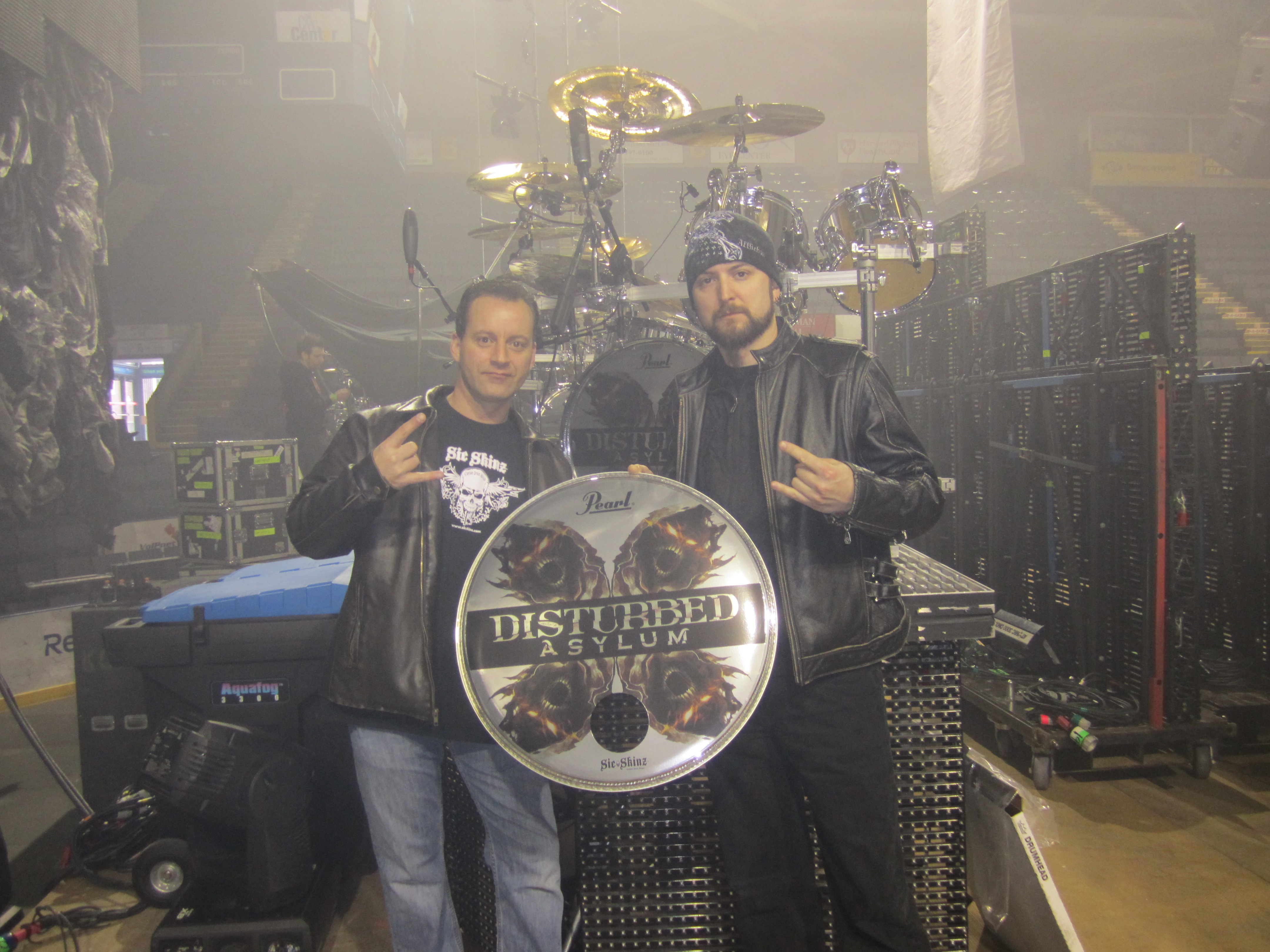 Michael Pesce with Disturbed drummer Mike Wengren holding the Asylum drumhead